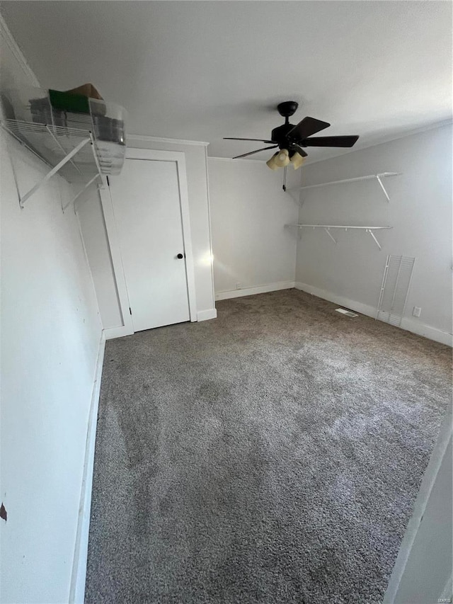 interior space featuring ceiling fan and dark carpet