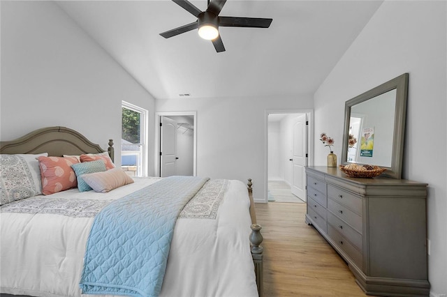 bedroom featuring lofted ceiling, a spacious closet, light hardwood / wood-style flooring, and ceiling fan