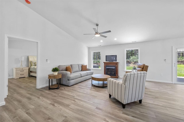 living room with ceiling fan, vaulted ceiling, and light hardwood / wood-style flooring