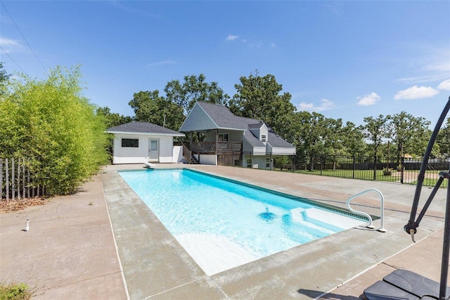 view of pool featuring a patio and an outbuilding