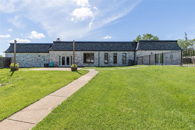 exterior space with cooling unit, a front yard, and french doors