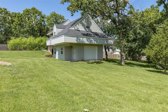 exterior space featuring a garage, an outdoor structure, and a lawn