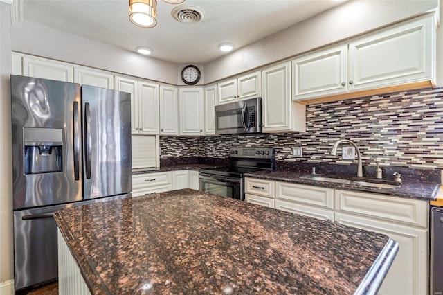 kitchen with decorative backsplash, stainless steel appliances, and white cabinets