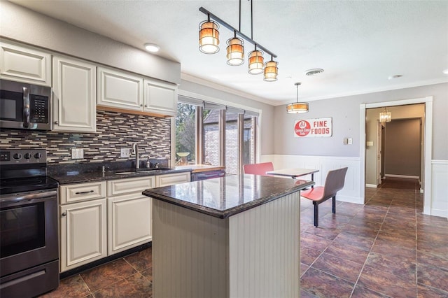 kitchen featuring a kitchen island, appliances with stainless steel finishes, pendant lighting, backsplash, and ornamental molding