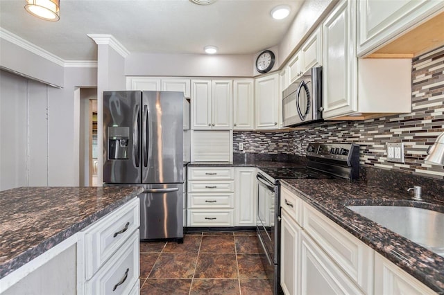 kitchen with dark stone countertops, decorative backsplash, stainless steel appliances, and white cabinets