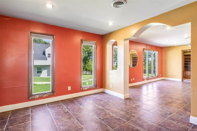 tiled empty room featuring a wealth of natural light