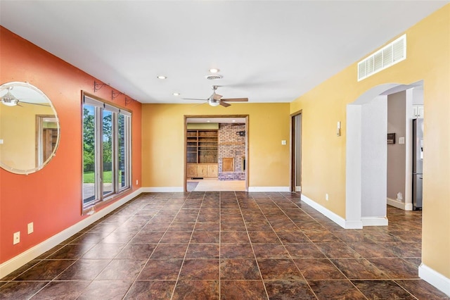 unfurnished living room featuring ceiling fan and a fireplace