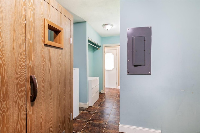 corridor with dark tile patterned floors and electric panel