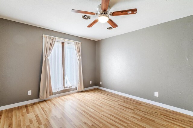 unfurnished room with light wood-type flooring, ceiling fan, and a wealth of natural light