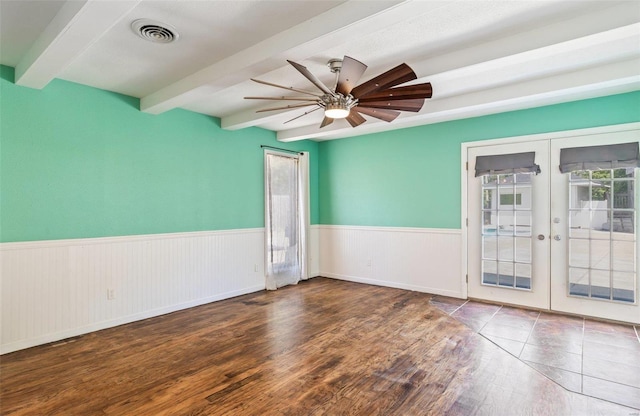 empty room with beamed ceiling, french doors, hardwood / wood-style floors, and ceiling fan