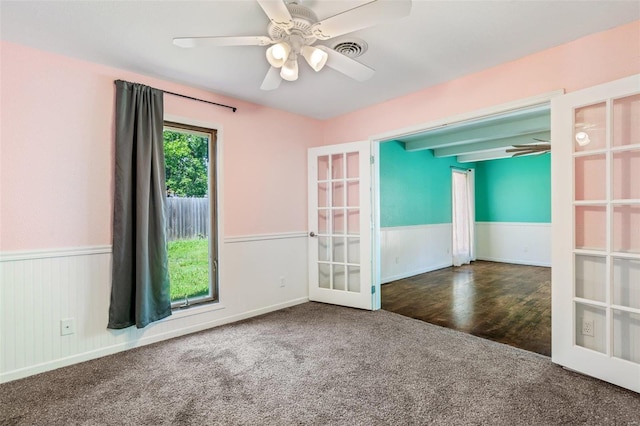 carpeted spare room with ceiling fan and french doors