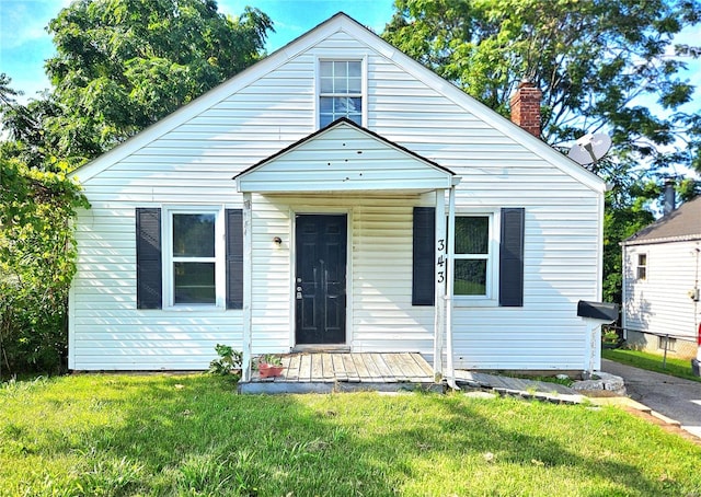 bungalow featuring a chimney and a front lawn