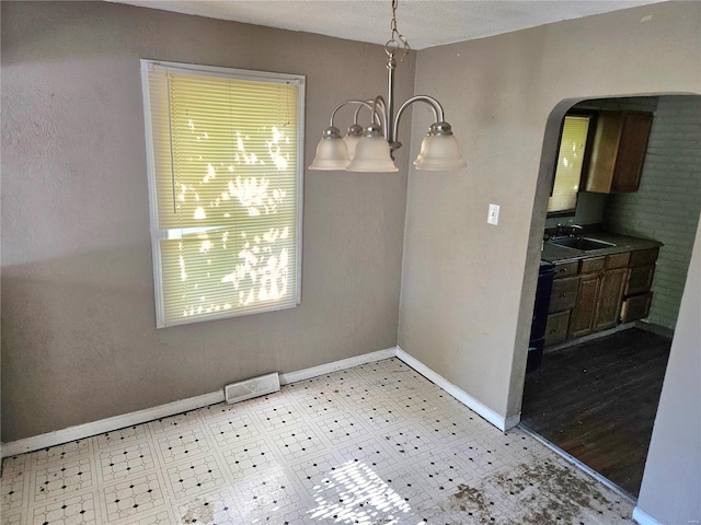 dining space featuring arched walkways, visible vents, baseboards, and tile patterned floors