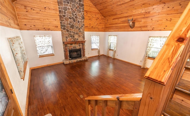 unfurnished living room with high vaulted ceiling, wood ceiling, plenty of natural light, and a stone fireplace