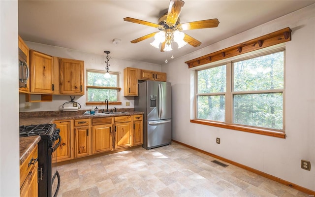 kitchen with range with gas cooktop, sink, hanging light fixtures, stainless steel fridge with ice dispenser, and ceiling fan