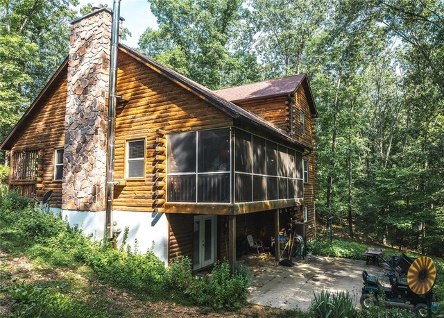 rear view of house featuring a patio area and a sunroom