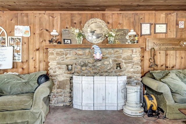 living room featuring a stone fireplace, wooden ceiling, and wooden walls