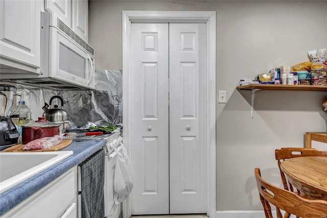 kitchen featuring white cabinetry, white appliances, and tasteful backsplash