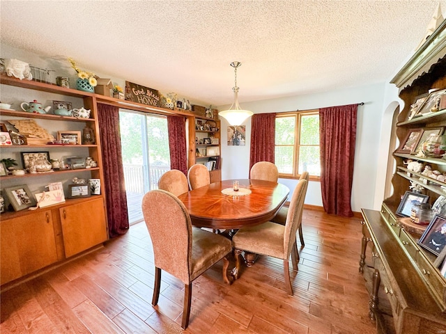 dining area featuring light hardwood / wood-style flooring and a textured ceiling