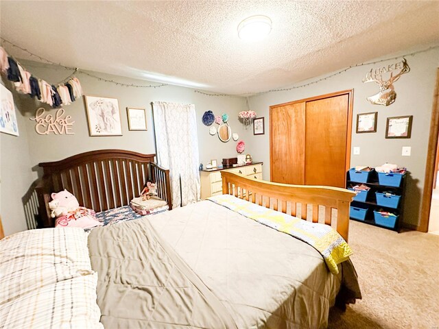 carpeted bedroom with a textured ceiling and a closet