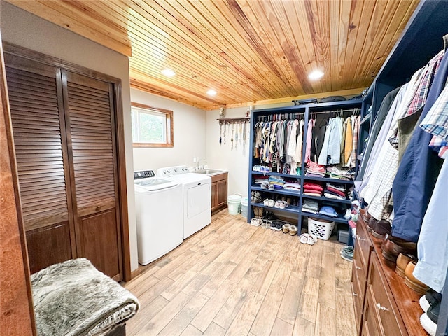 laundry area featuring washing machine and dryer, light wood-type flooring, sink, and wooden ceiling