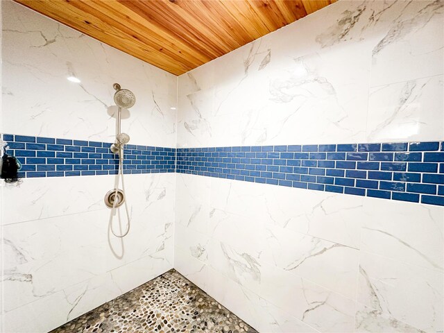 bathroom featuring a tile shower and wood ceiling