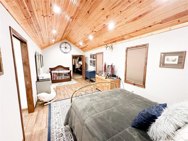 bedroom with wood ceiling, light hardwood / wood-style floors, and vaulted ceiling