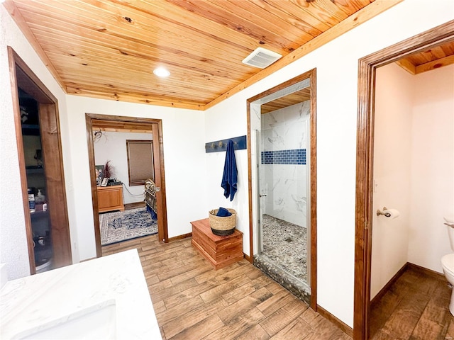 hall with wood ceiling, ornamental molding, and light hardwood / wood-style flooring