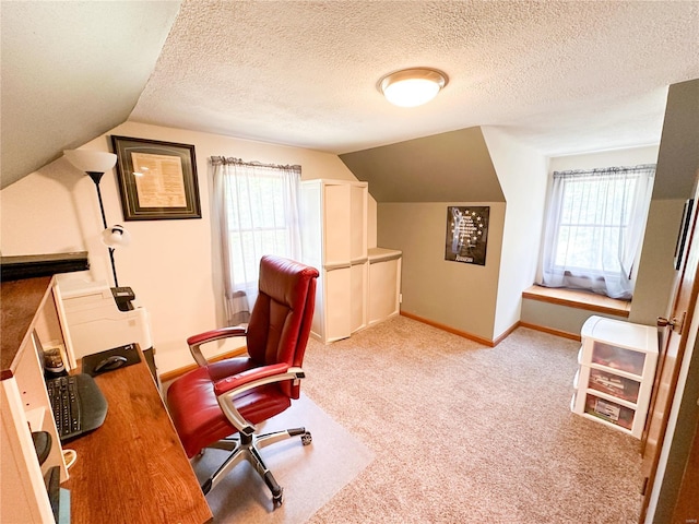 carpeted office space featuring a textured ceiling and vaulted ceiling