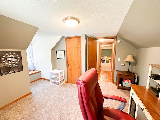 carpeted home office with a textured ceiling and lofted ceiling