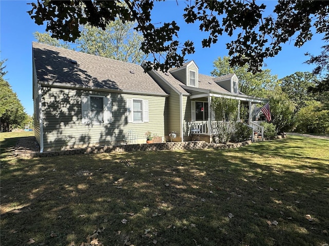 cape cod-style house with covered porch and a front yard