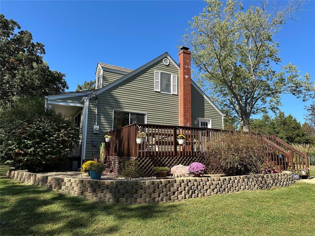 rear view of property featuring a lawn and a deck