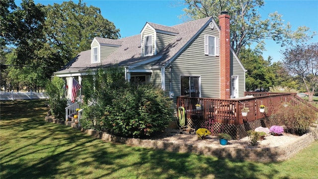 back of house featuring a lawn and a deck