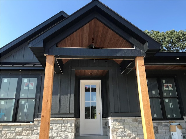 doorway to property with stone siding and board and batten siding