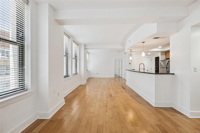 unfurnished living room featuring light hardwood / wood-style flooring and sink