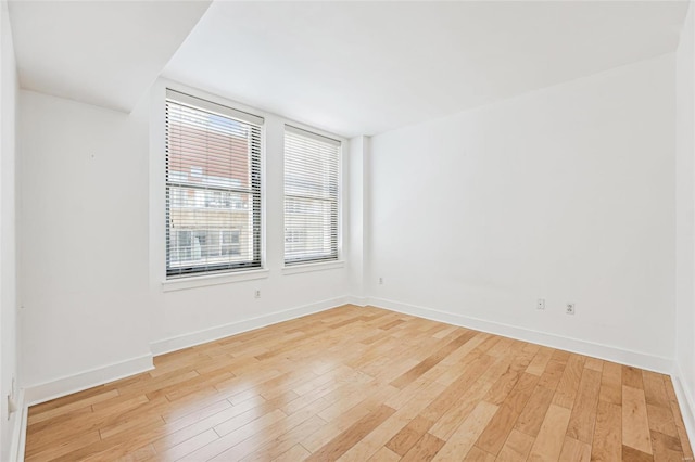 unfurnished room featuring a wealth of natural light and light hardwood / wood-style flooring