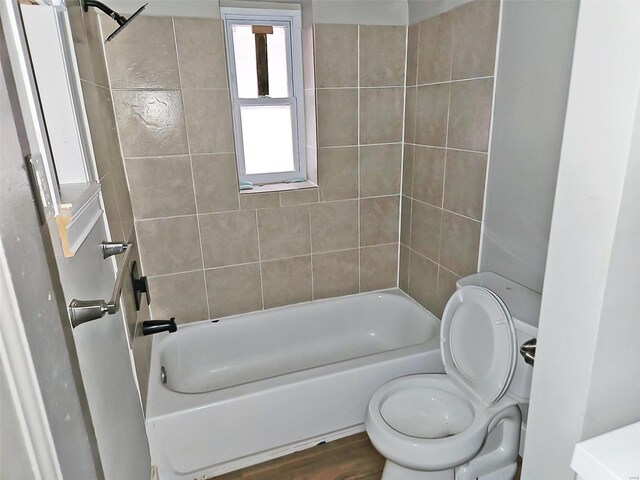 bathroom featuring toilet, tiled shower / bath combo, and hardwood / wood-style floors