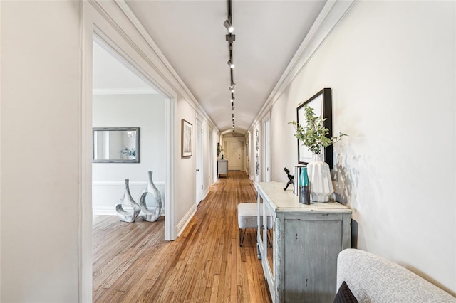 hallway featuring ornamental molding, hardwood / wood-style floors, and track lighting