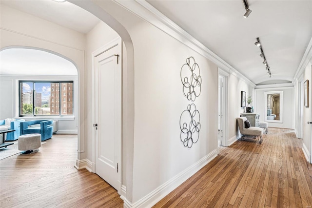 hallway featuring wood-type flooring and rail lighting