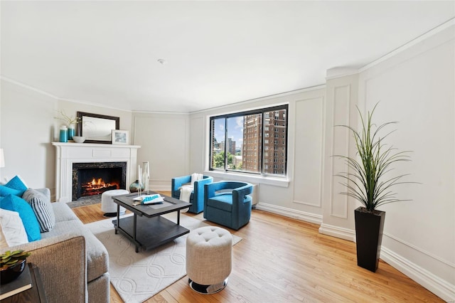 living room with a high end fireplace and light hardwood / wood-style flooring