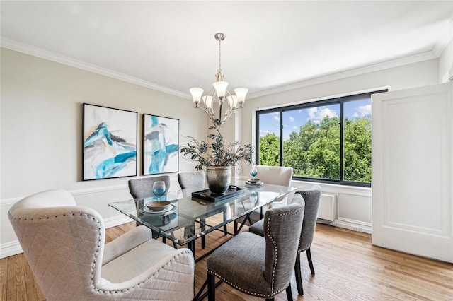 dining room featuring crown molding, light hardwood / wood-style floors, and a notable chandelier