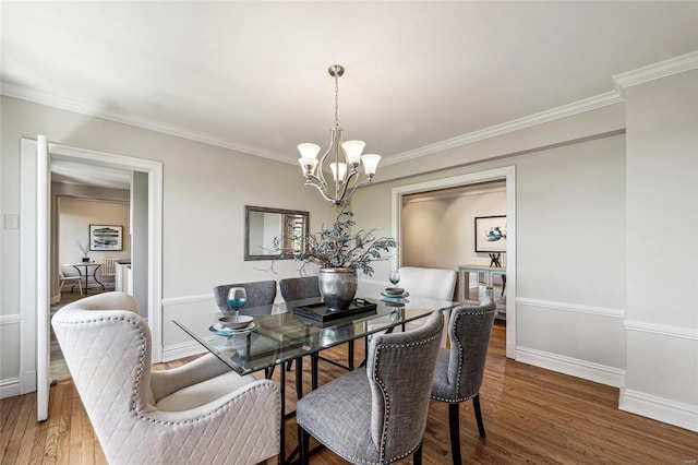 dining area featuring an inviting chandelier, crown molding, and wood-type flooring