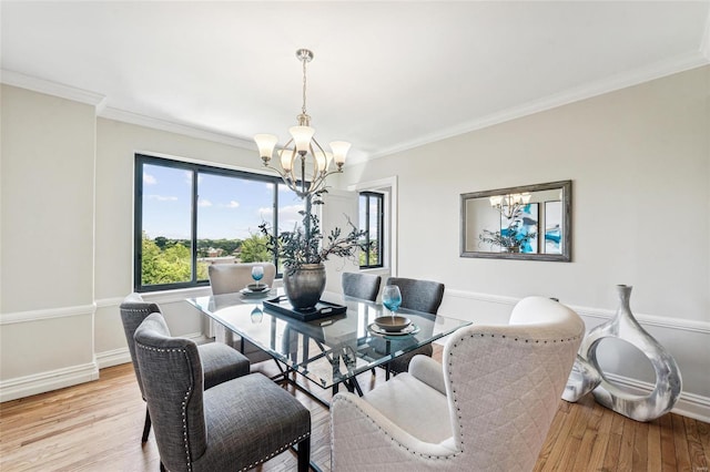 dining space featuring crown molding, a chandelier, and light hardwood / wood-style flooring