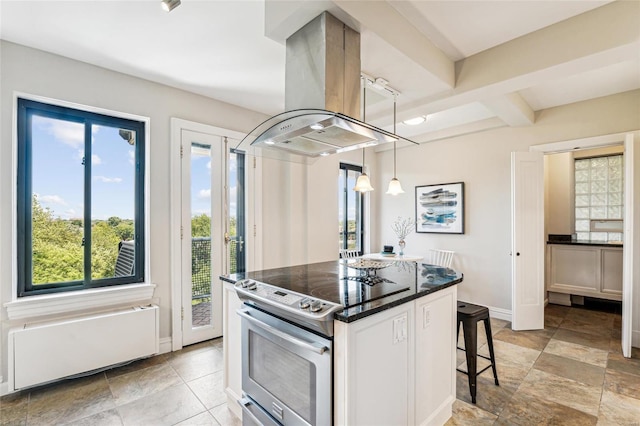 kitchen featuring electric range, a kitchen breakfast bar, a center island, island range hood, and decorative light fixtures