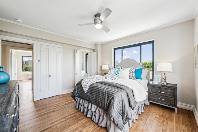 bedroom with ceiling fan, ornamental molding, and light wood-type flooring