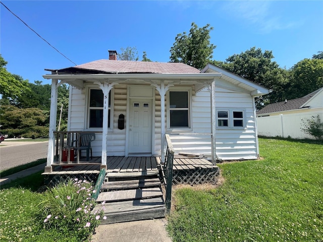 bungalow with covered porch and a front yard