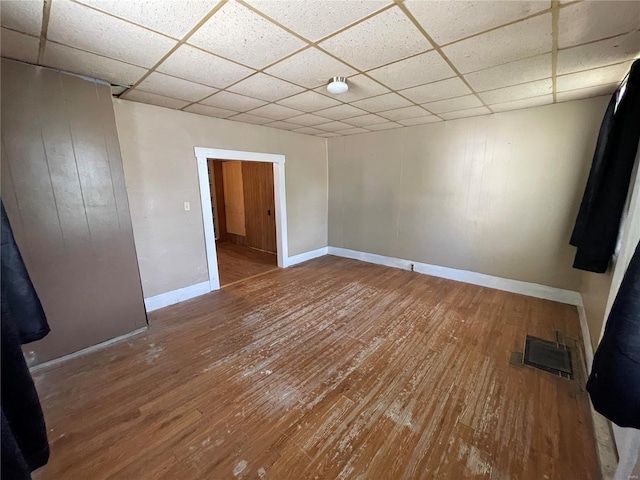 spare room featuring hardwood / wood-style flooring and a paneled ceiling