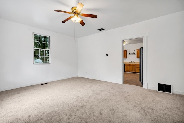 carpeted empty room featuring ceiling fan