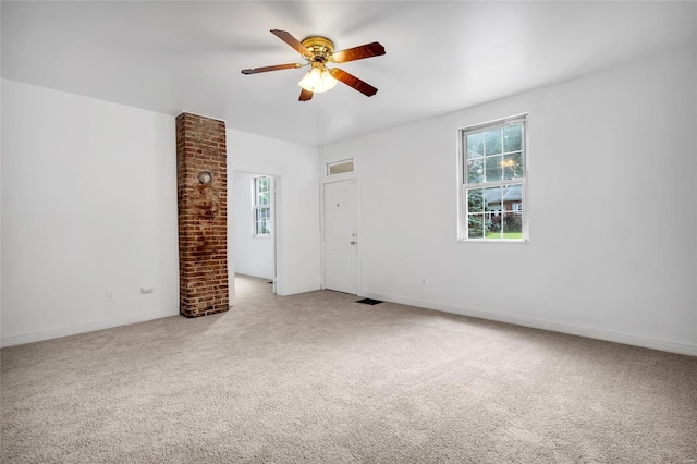 empty room featuring ceiling fan and carpet