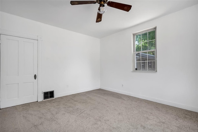 spare room with ceiling fan and light colored carpet